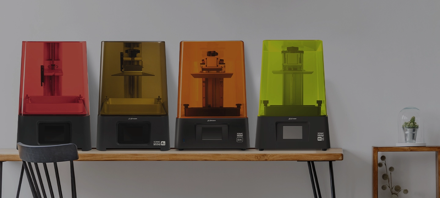Phrozen Sonic Mini Series resin 3D printers on a wooden table in four colors, compact and precise.